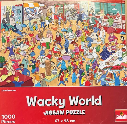 Wacky world Lunchroom 1000 st Wacky World Lunchroom legpuzzel van 1000 stukjes met op de puzzel een afbeelding van het leven tijdens een pandemie. Afmetingen puzzel: 68 x 48 cm, merk Goliath.
